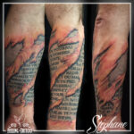 Tatouage - Peau effet "déchirée" en couleurs et lettrage sur l'avant-bras (cicatrisé)