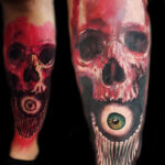 Tatouage - Crâne et oeil en couleurs sur le tibia à main levée
